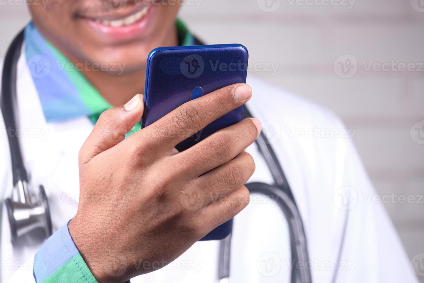 médico de jaleco branco usando um smartphone foto
