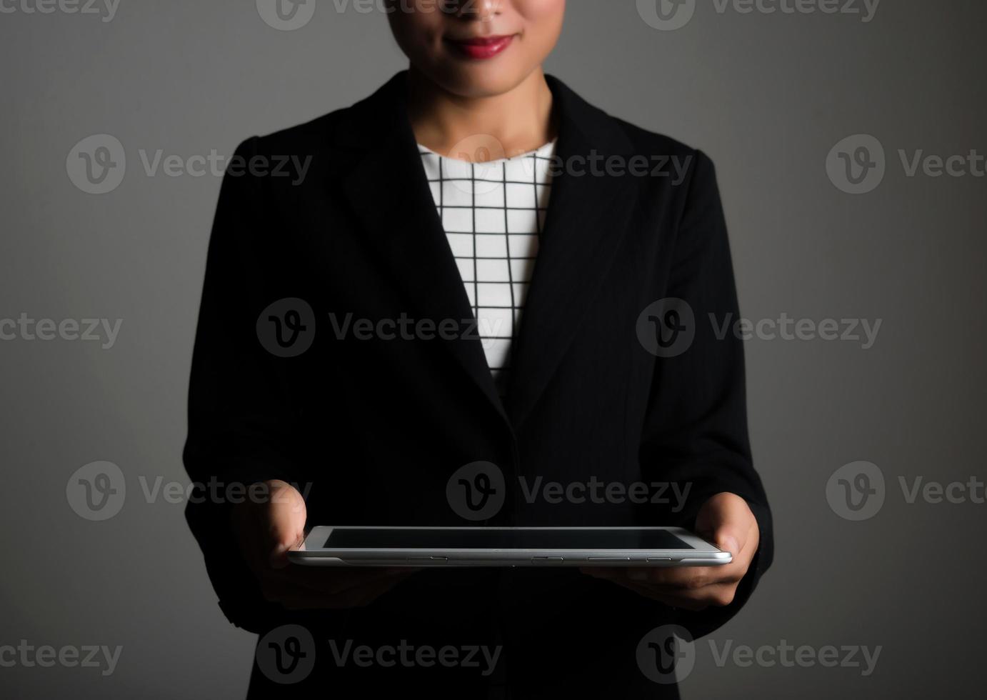 mulher segurando um tablet digital e olhando para uma tela em branco foto