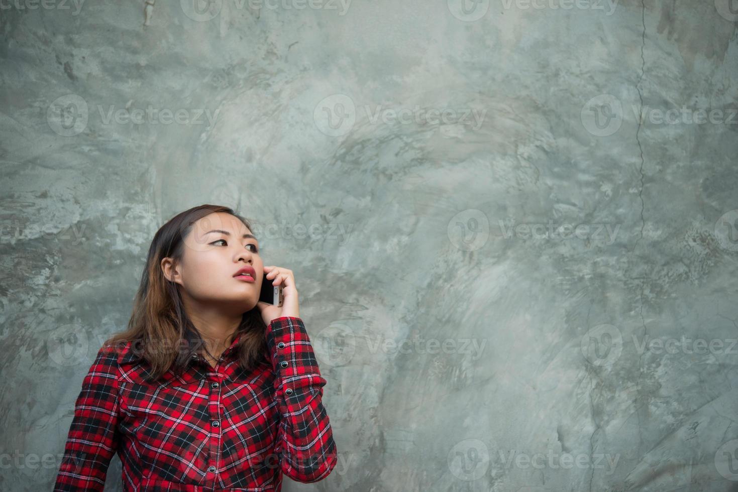 mulher jovem hippie segurando smartphone isolado no fundo do grunge foto