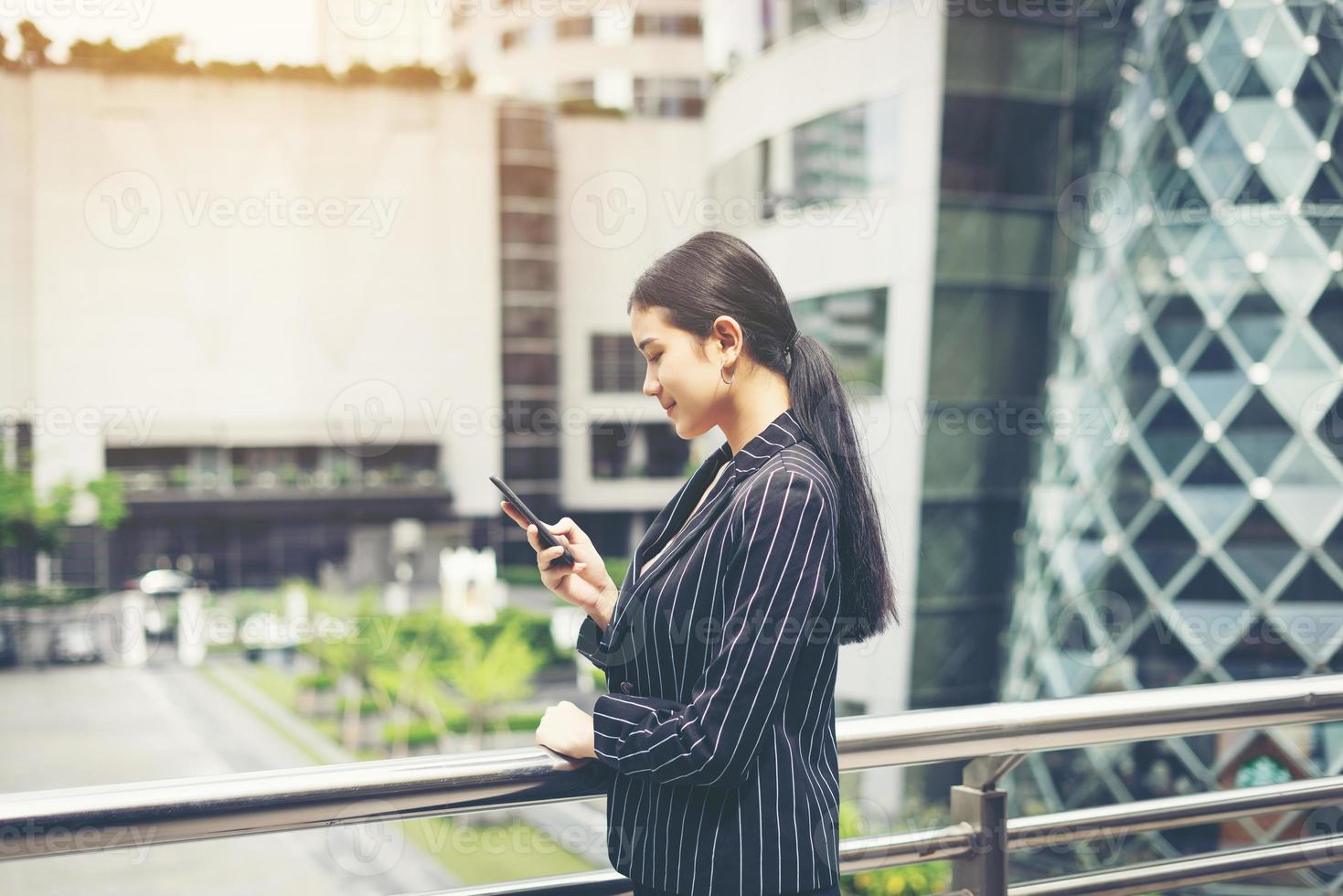 jovem mulher de negócios asiática usando telefone celular foto