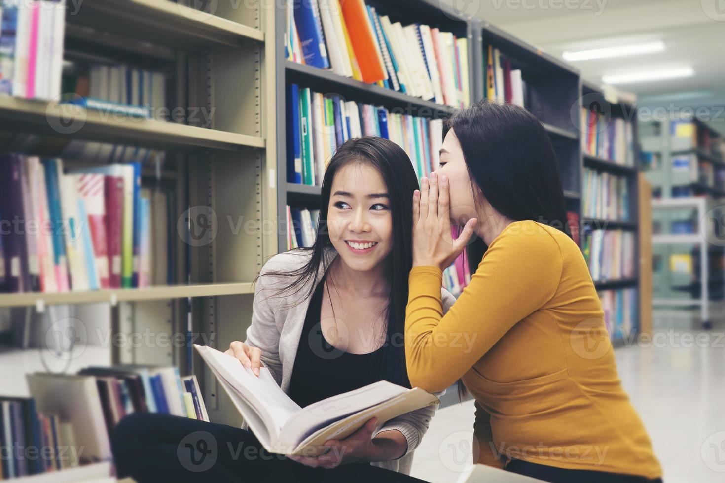 grupo de alunos felizes com livros conversando e se preparando para o exame na biblioteca foto