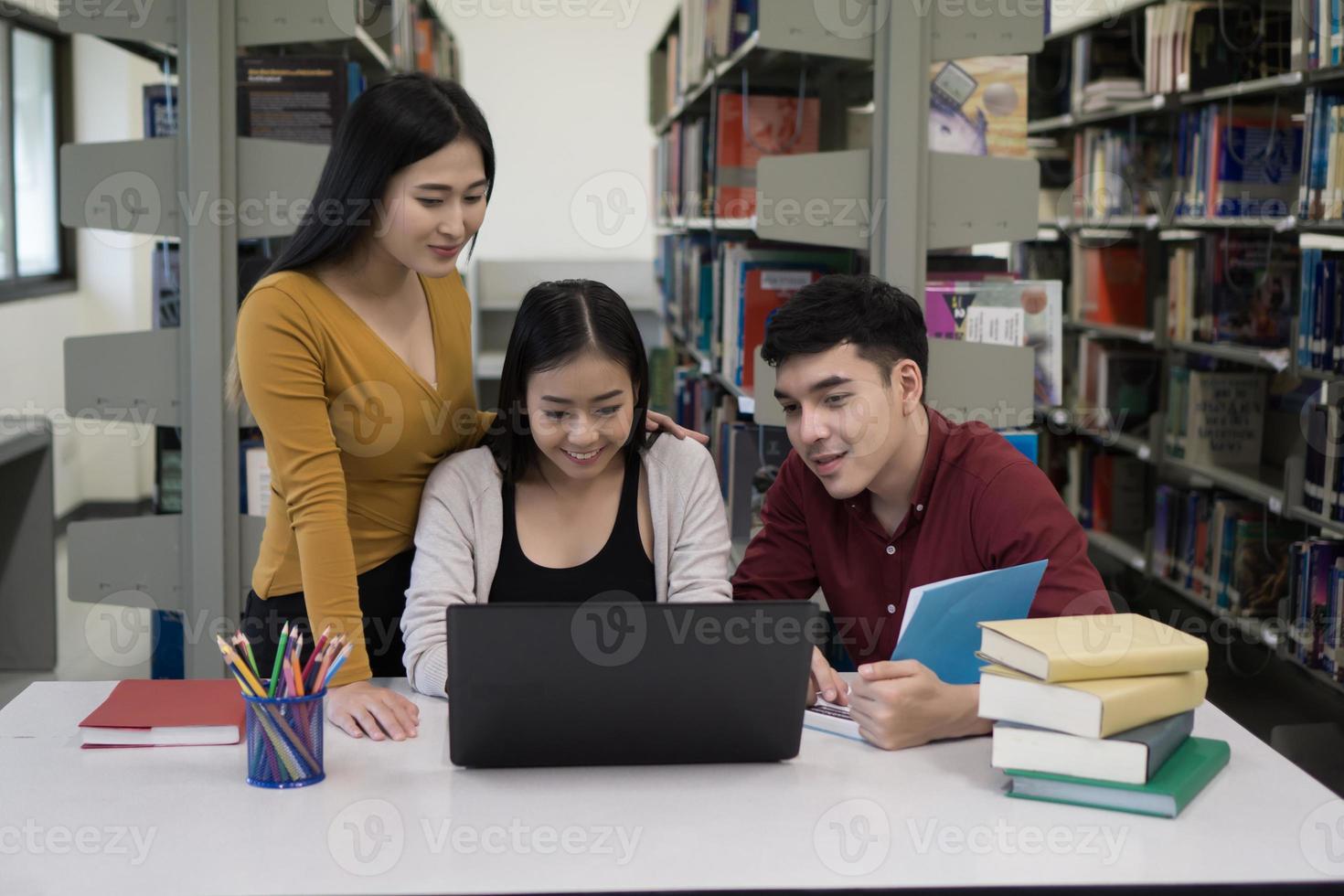 grupo de estudantes universitários estudando na biblioteca da escola foto