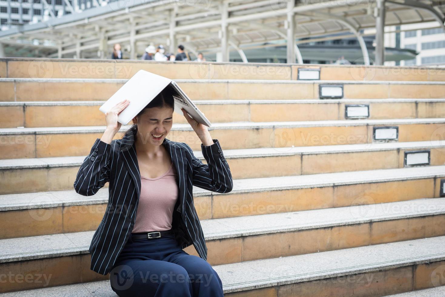 mulher de negócios estressada enquanto usa o laptop nas escadas foto