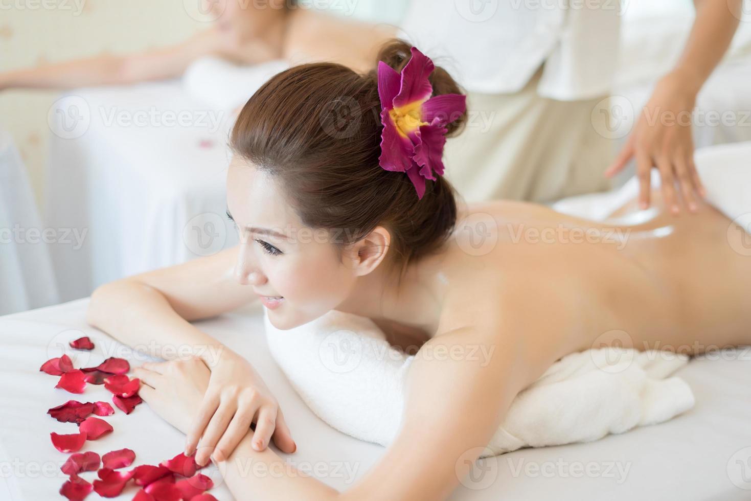 jovem mulher bonita com massagem saudável em um salão de spa foto