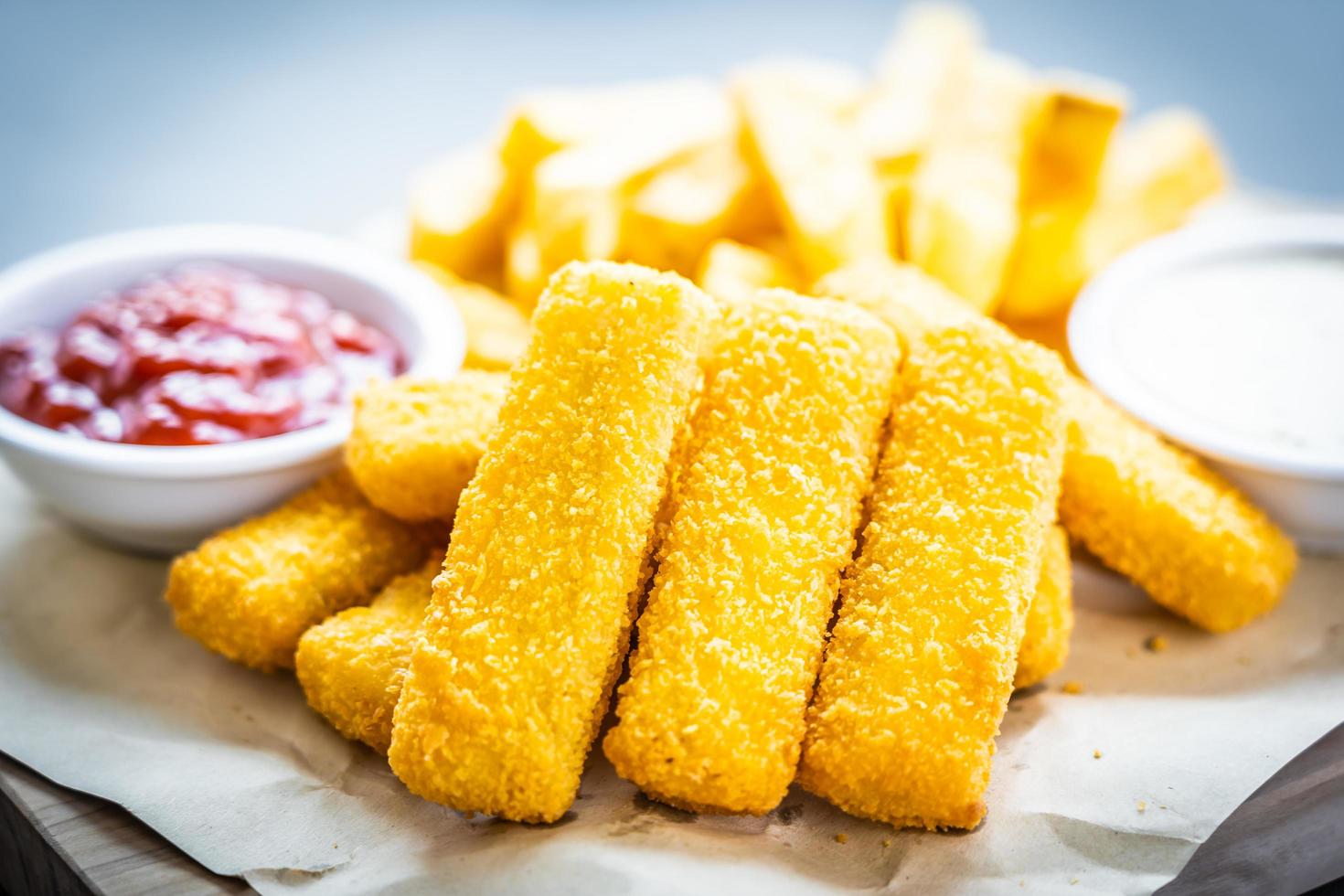 dedo de peixe e batatas fritas com molho de ketchup e maionese foto