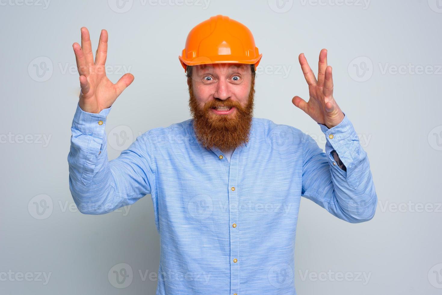 isolado feliz arquiteto com barba e laranja capacete foto