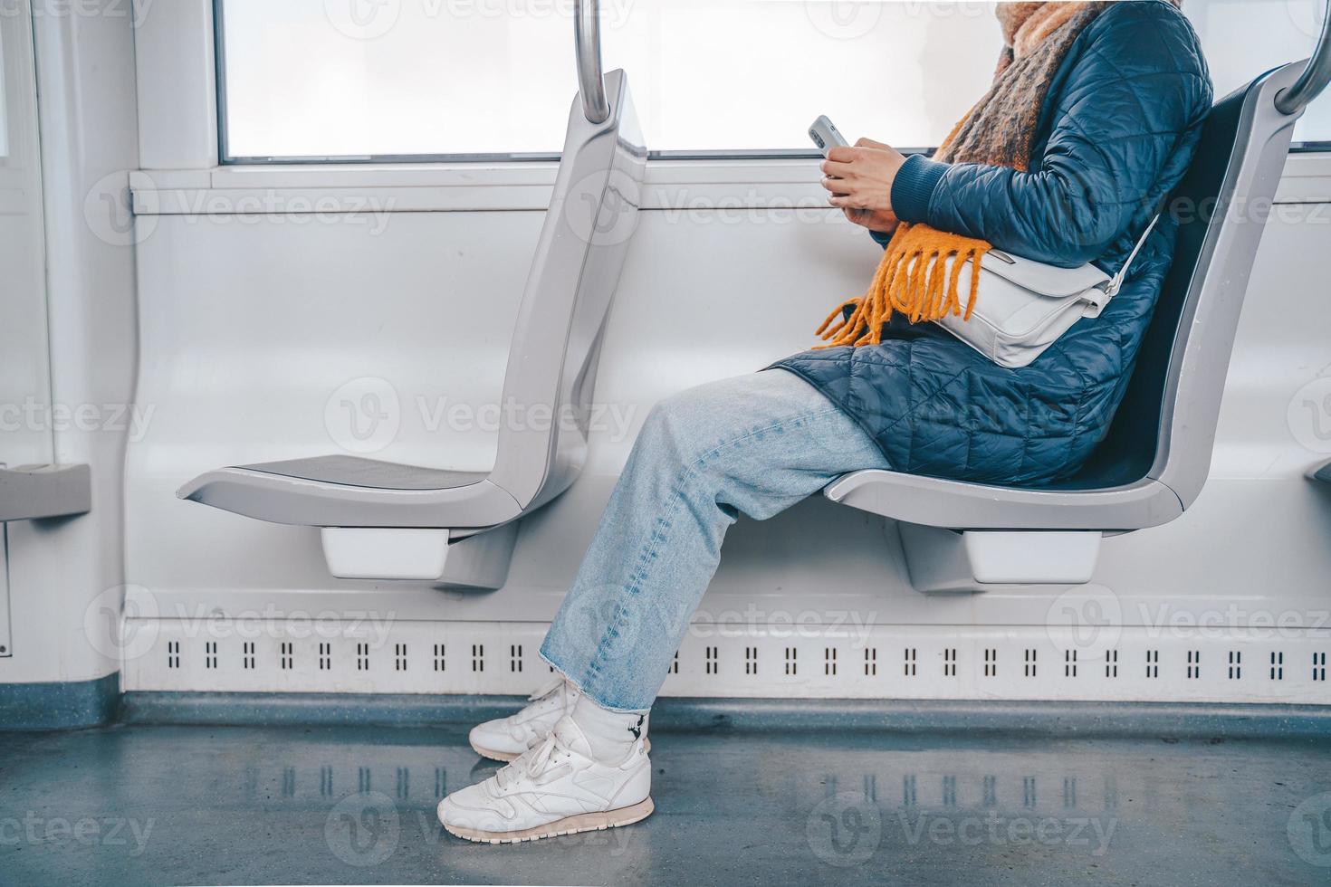 Senior mulher mandar mensagem com uma Móvel telefone dentro uma trem foto