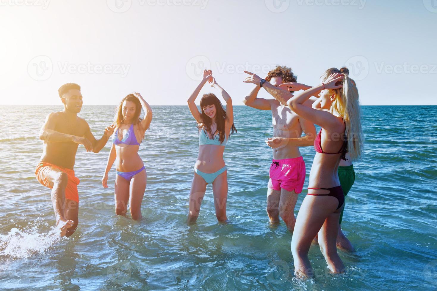 grupo do amigos tendo Diversão em a de praia. conceito do horário de verão foto