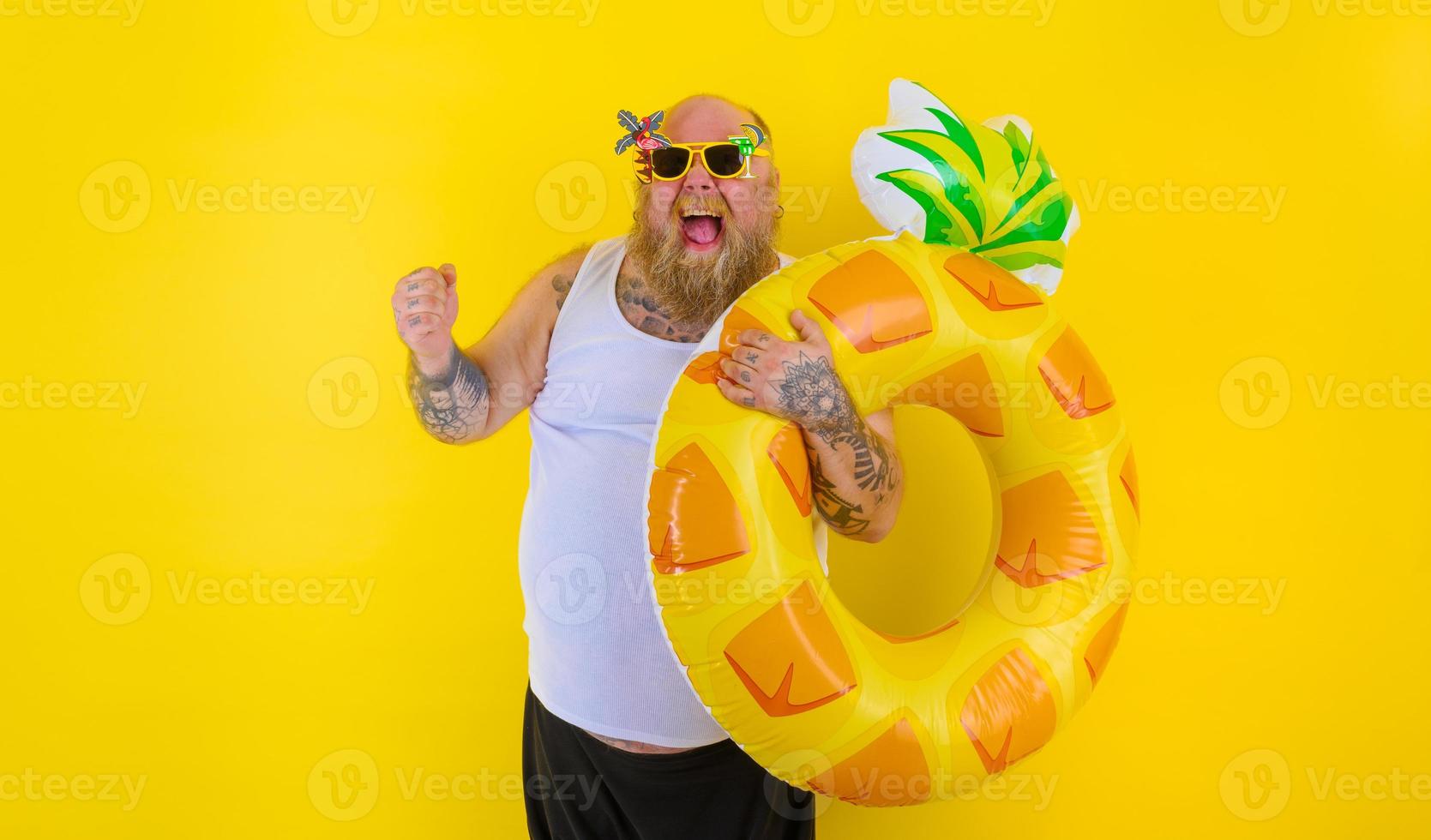 gordo feliz homem com peruca dentro cabeça é pronto para nadar com uma rosquinha salva-vidas foto