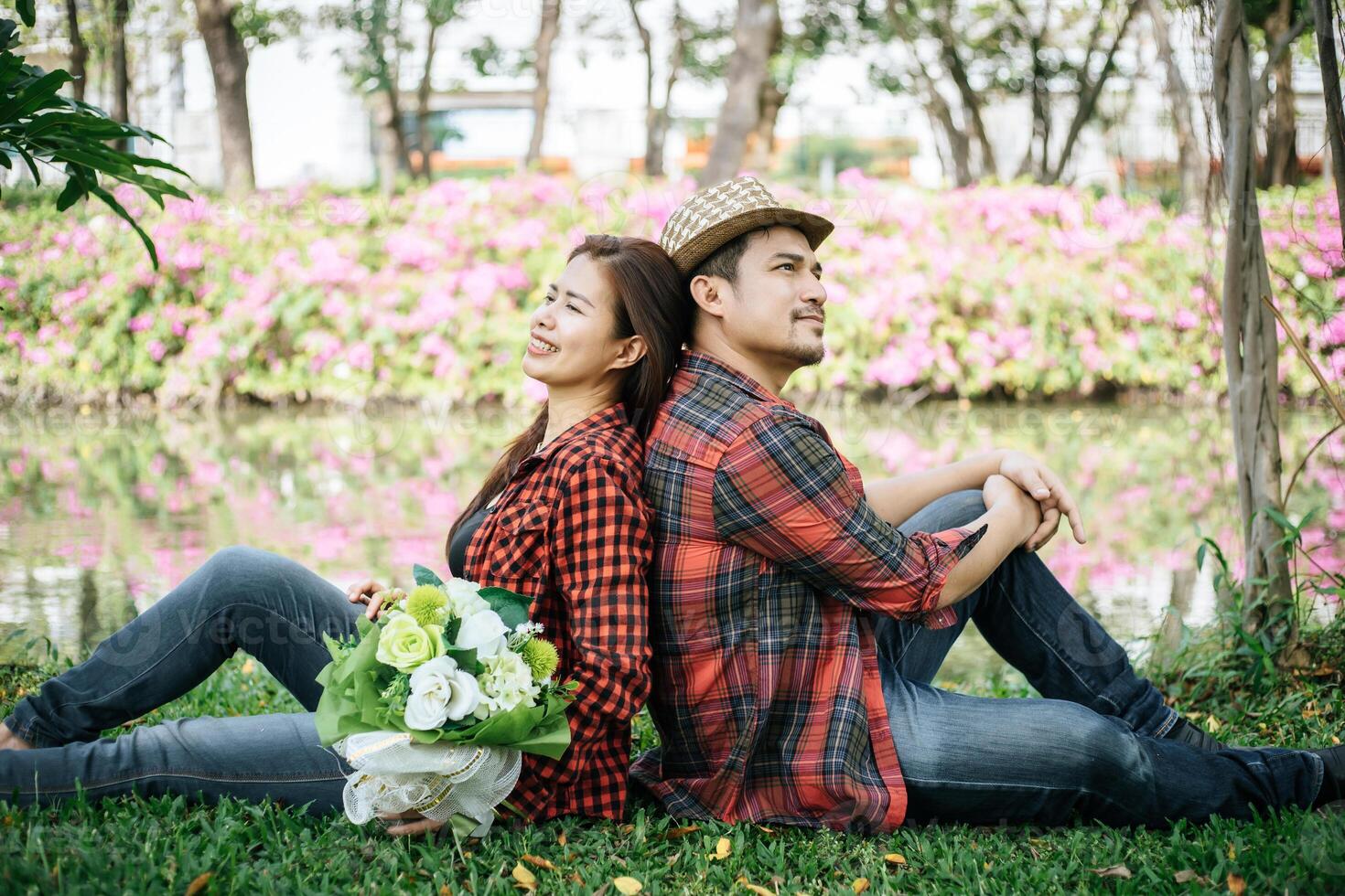 romântico jovem casal sentado dentro jardim foto