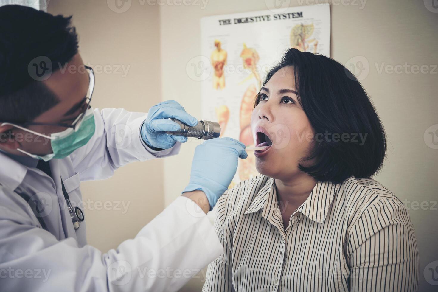 médico dentro branco uniforme vestido checar pacientes boca com lanterna foto