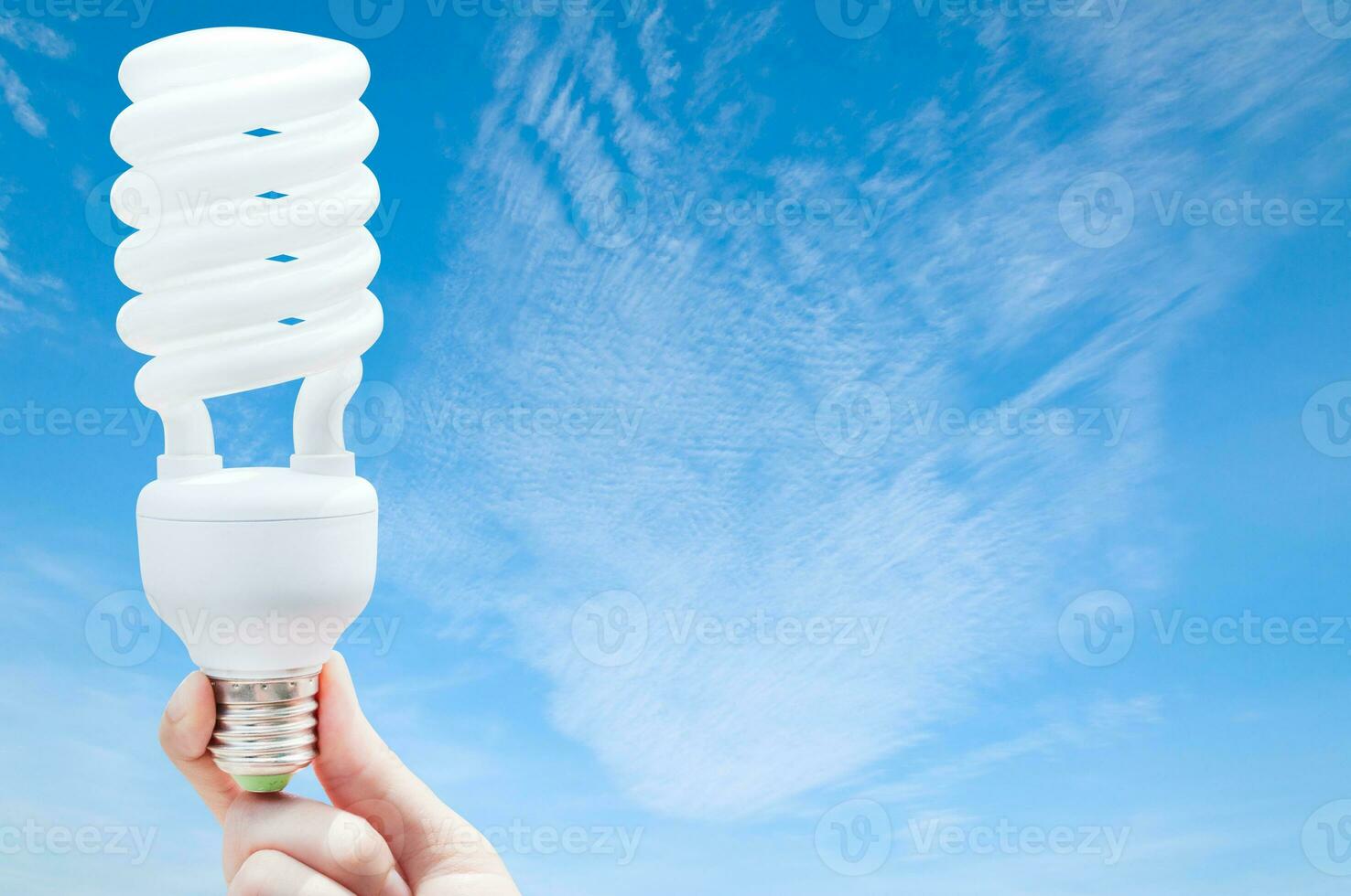 energia salvando conceito, mulher mão segurando luz lâmpada em azul céu plano de fundo, ideias luz lâmpada dentro a mão foto