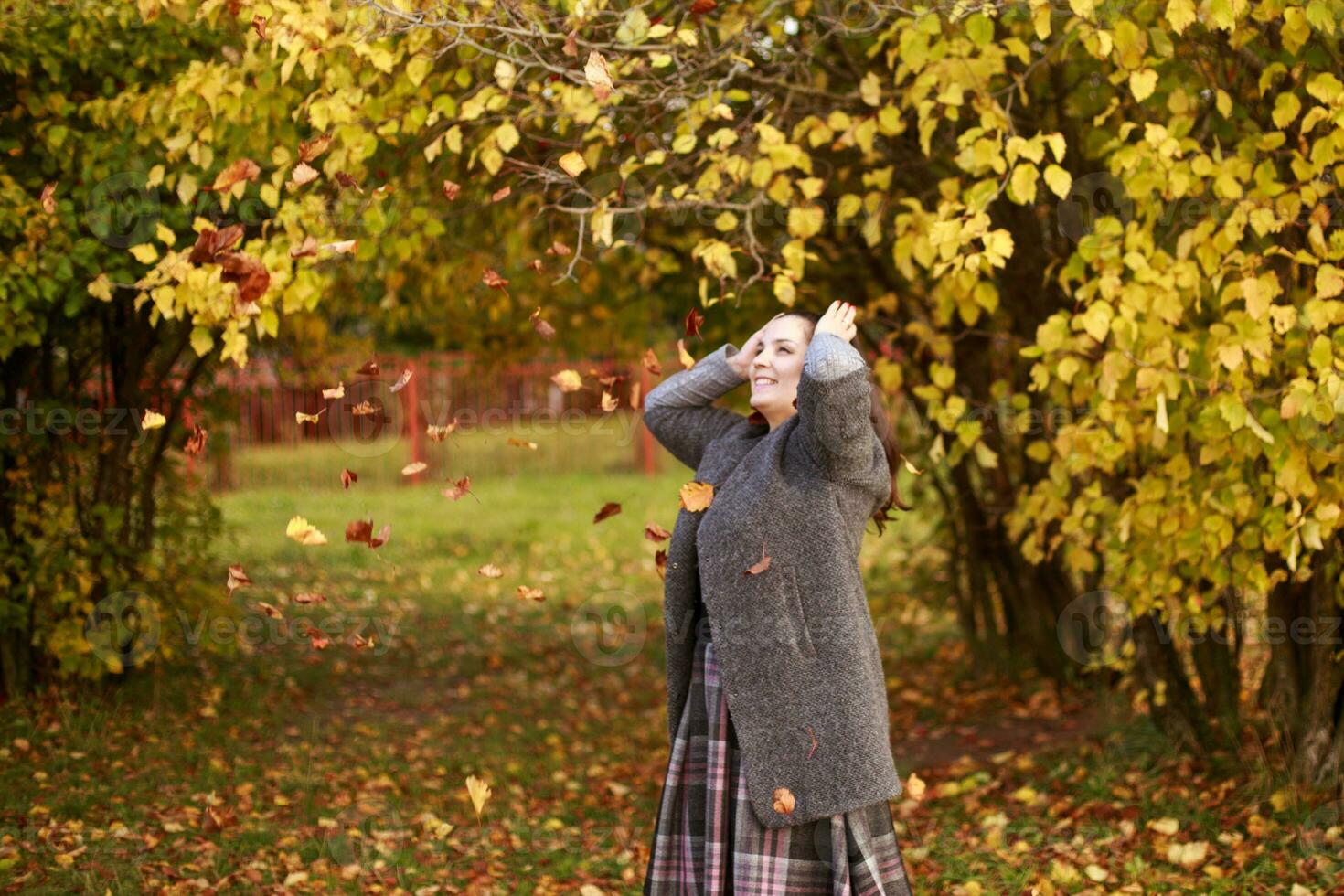 menina dentro a parque lança outono folhas foto