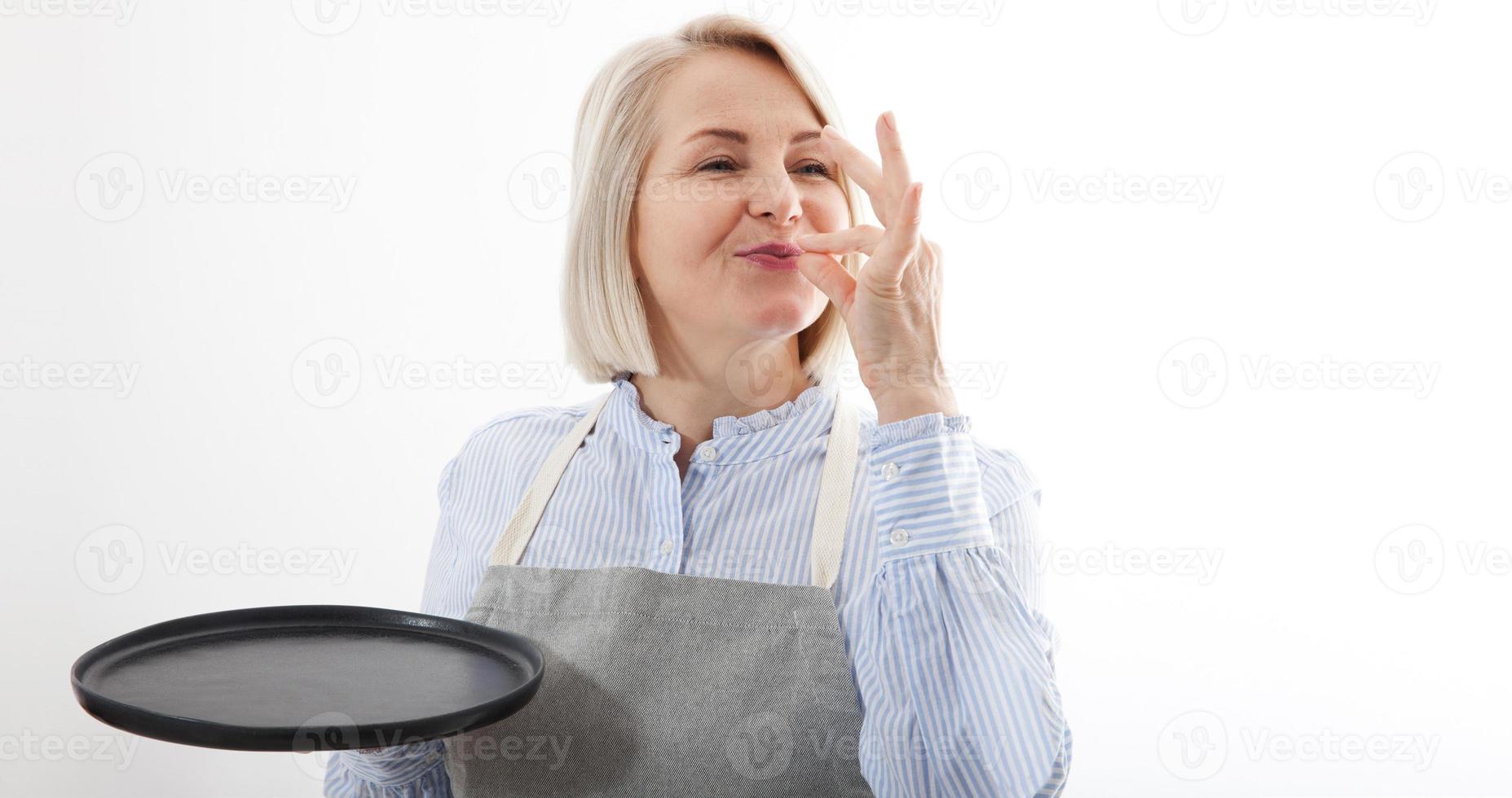 chefe de cozinha mulher mostrando placa para delicioso. fêmea chefe de cozinha dentro uniforme com perfeito placa segurando esvaziar placa. satisfeito chefe de cozinha, cozinhar ou padeiro gesticulando excelente. cozinhar com gosto aprovação gesto. zombar acima. foto