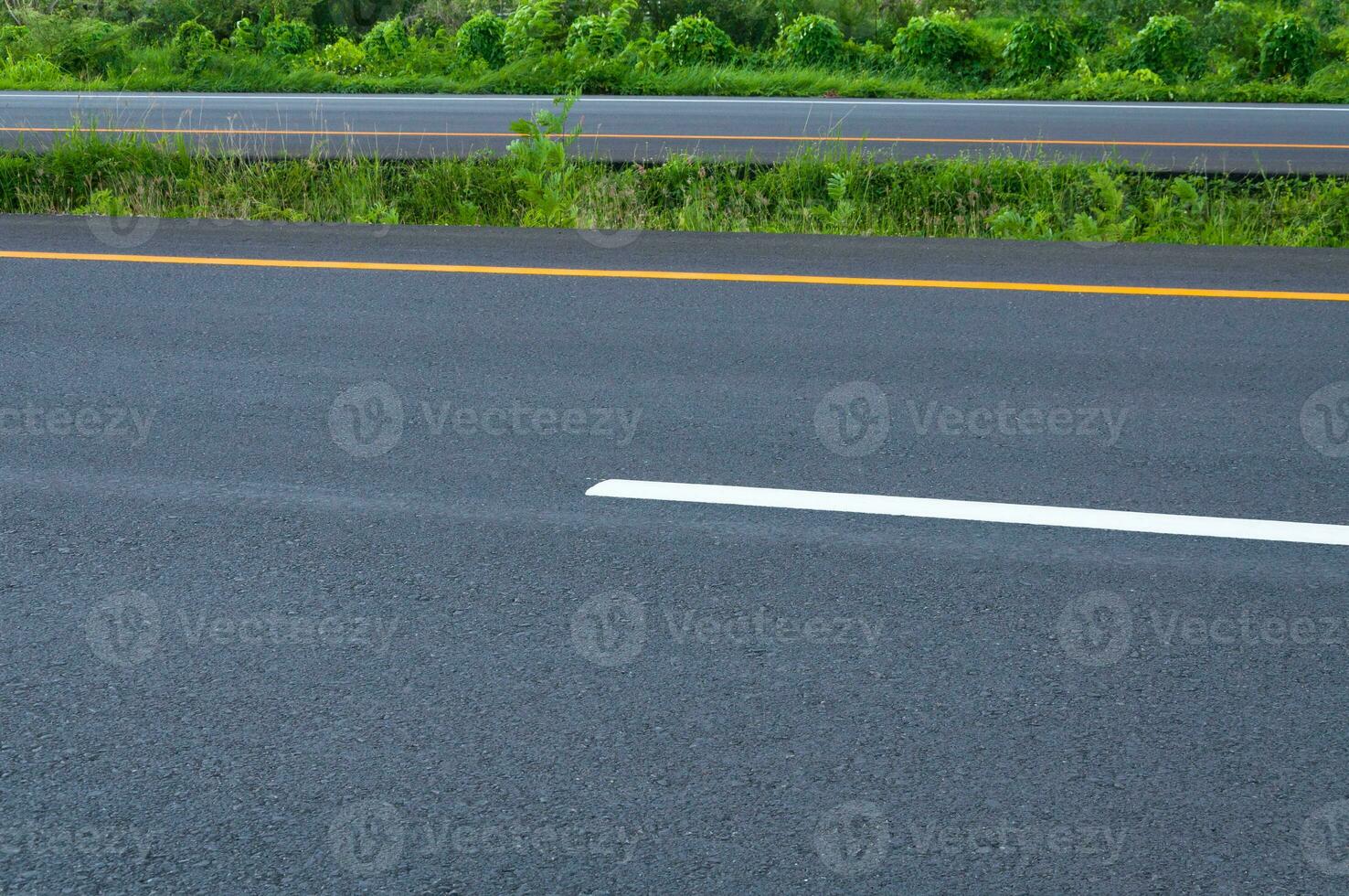 esvaziar rodovia com dividindo linha, beira da estrada e verde grama, abstrato transporte fundo, asfalto estrada Novo construção foto