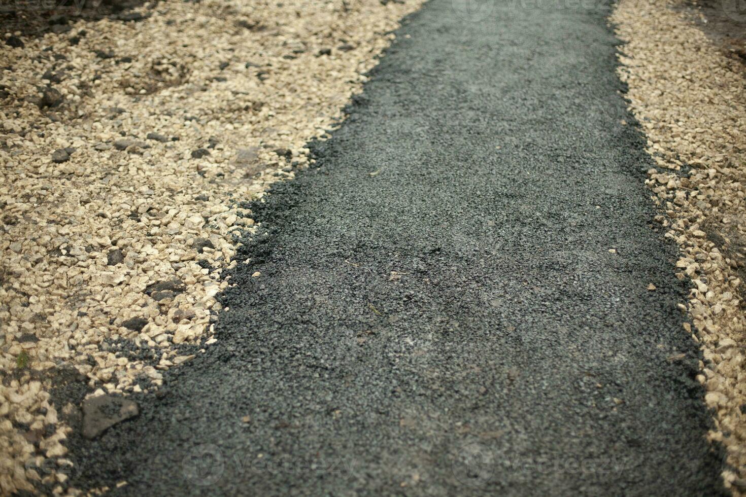 asfalto novo. construção de caminho no parque. detalhes da superfície da estrada. foto