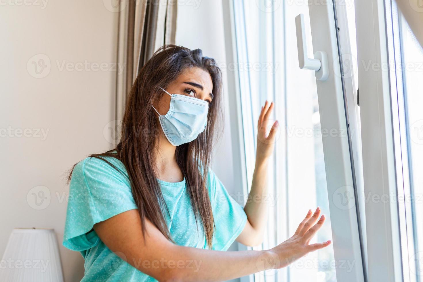 casa quarentena. caucasiano mulher sentado às janela dentro uma médico mascarar, olhando fora, quer para ir fora. proteção contra coronavírus infecção, pandemias, doença surtos e epidemias. foto