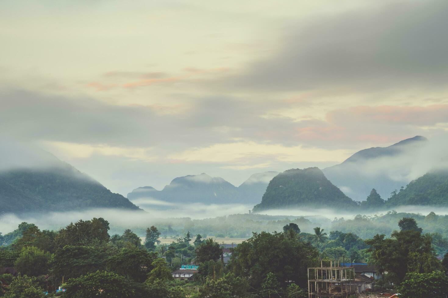 lindo nascer do sol e branco névoa com montanha às vang vieng, Laos. foto