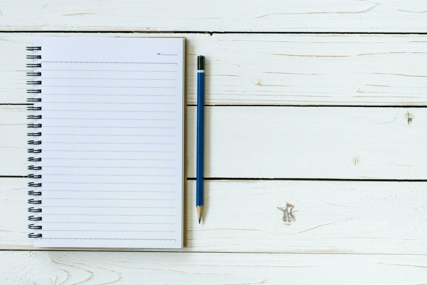 caderno aberto com páginas em branco e lápis foto