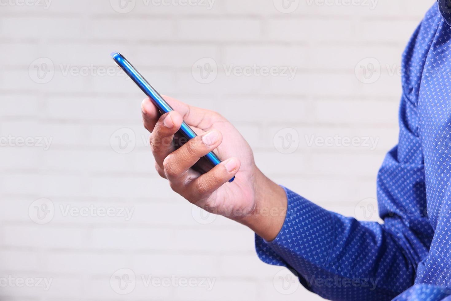mão segurando um telefone inteligente azul foto