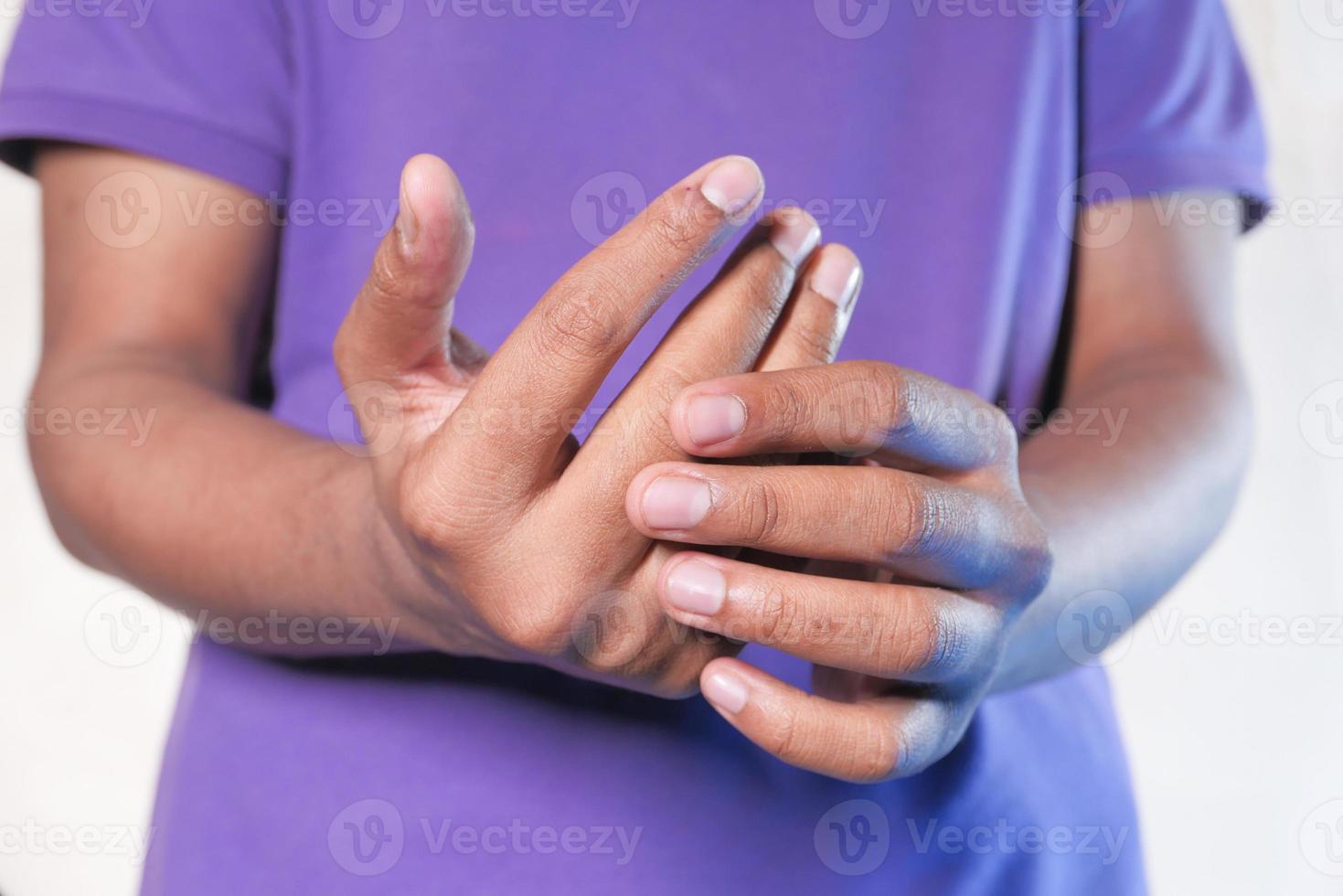 homem segurando dedo com dor foto