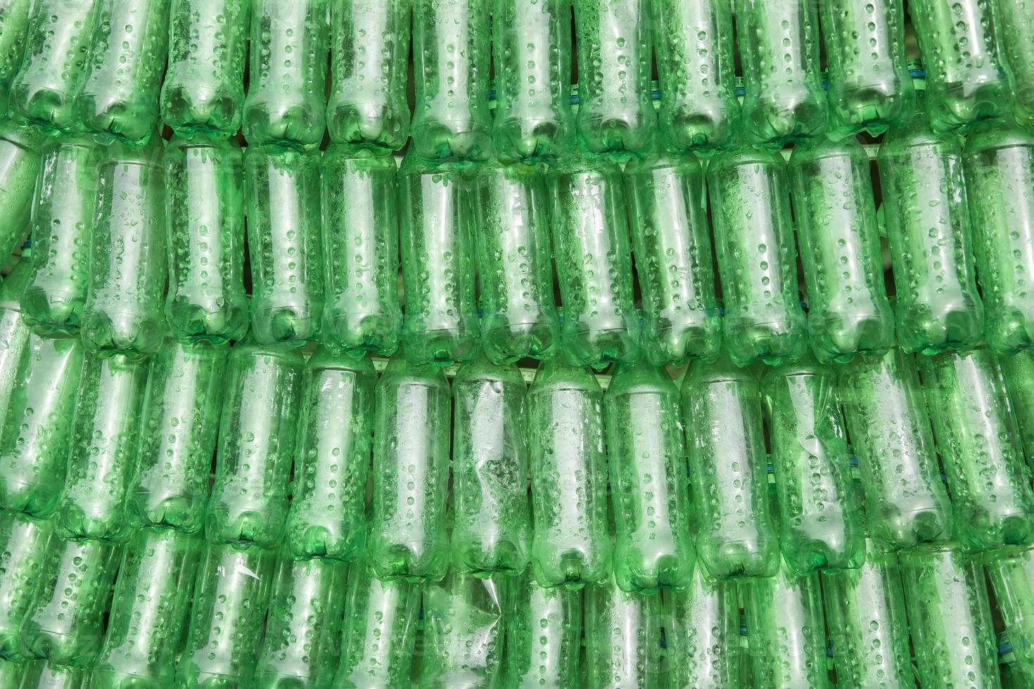 filas de garrafas de plástico verdes empilhadas lado a lado foto