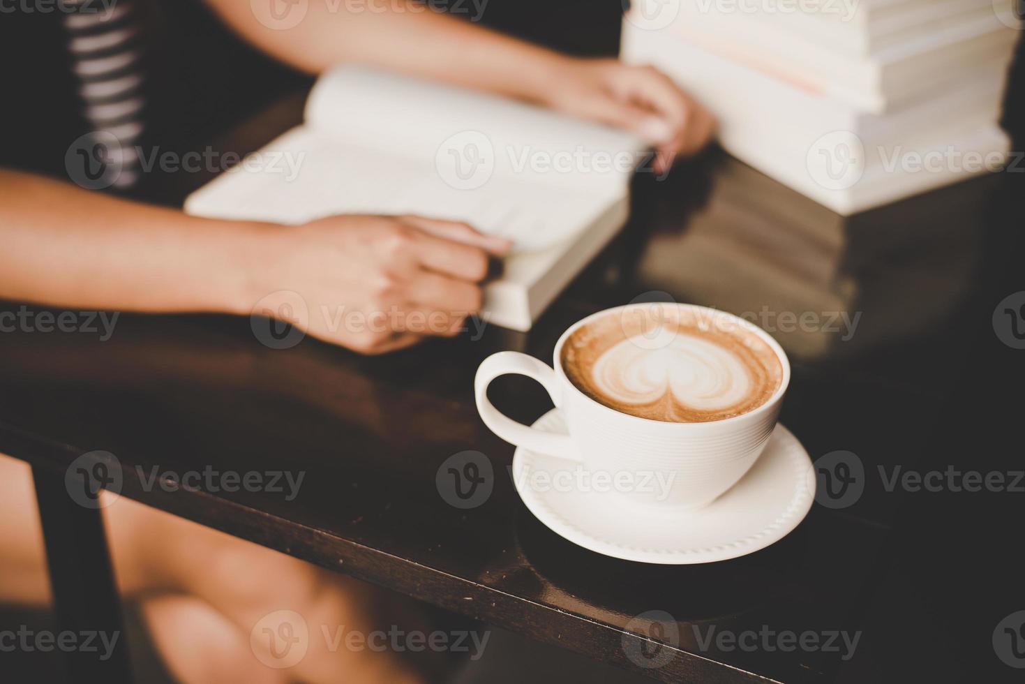 mulher relaxando e lendo um livro em um café foto