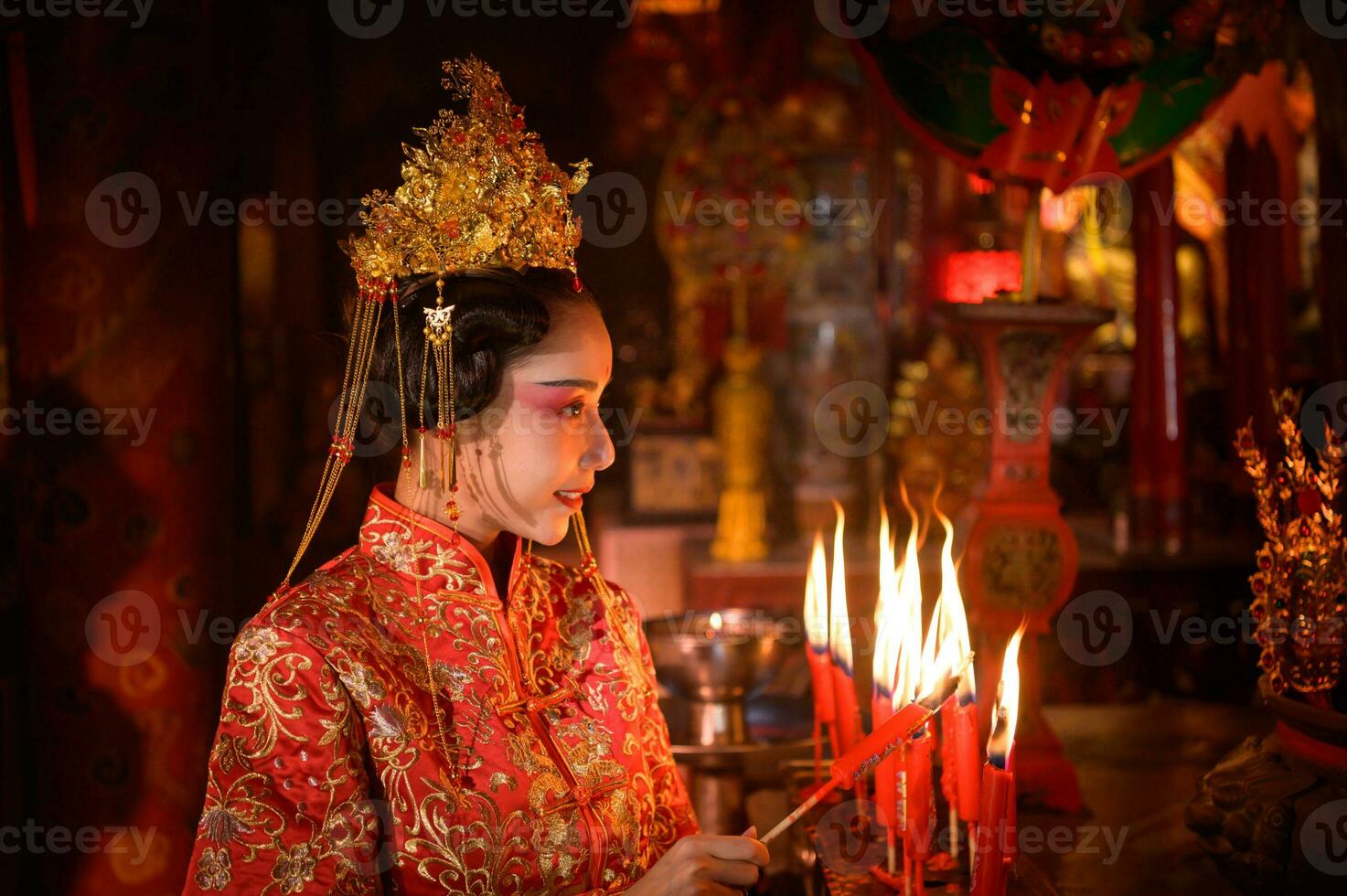 chinês mulher faço desejos, rezar, e luz velas. em a ocasião do a anual chinês Novo ano festival, dentro uma reverenciado santuário ou têmpora foto