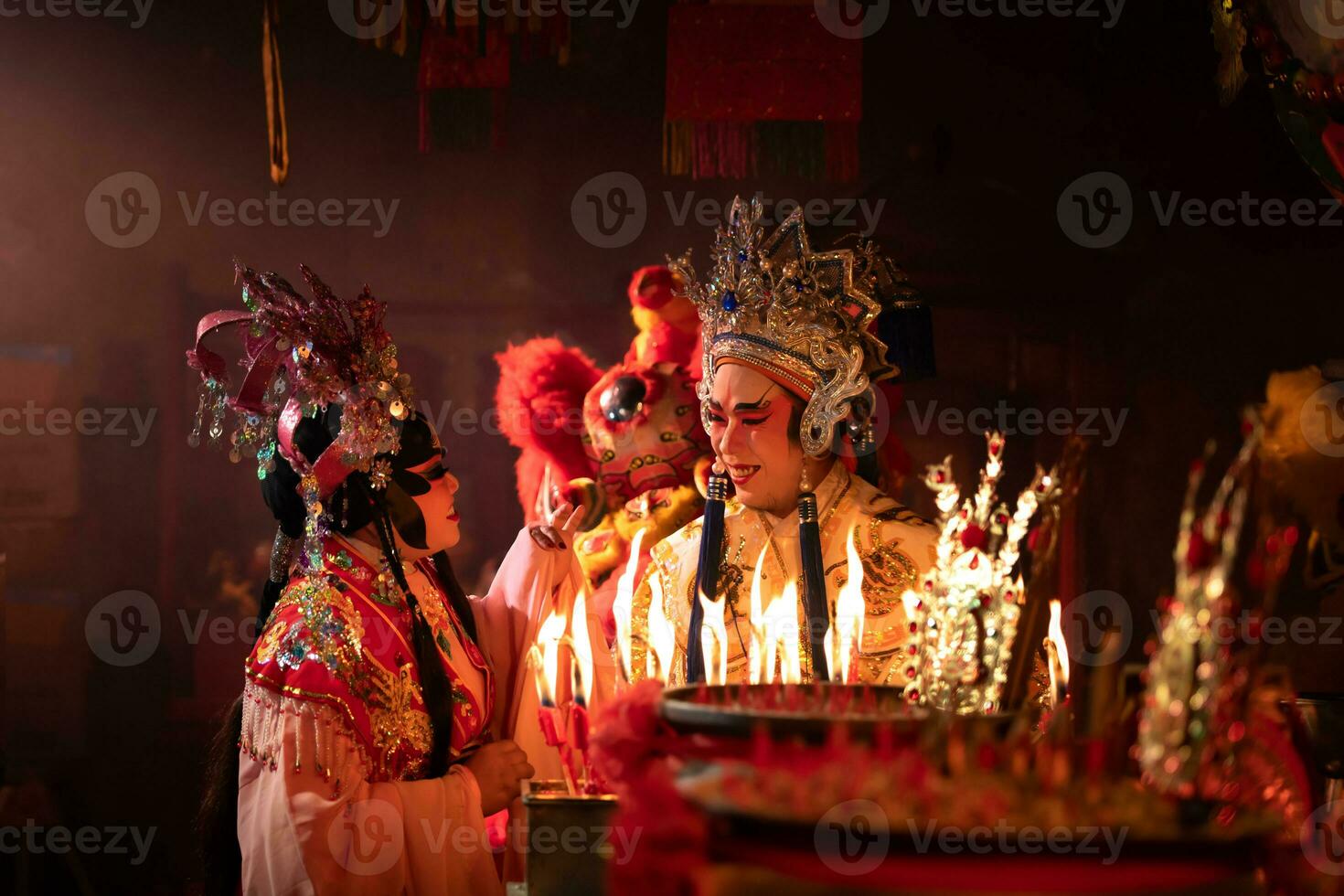 masculino e fêmea chinês ópera atores luz uma vela para orar homenagem para a Deuses para realçar a prosperidade para você mesmo em a ocasião foto