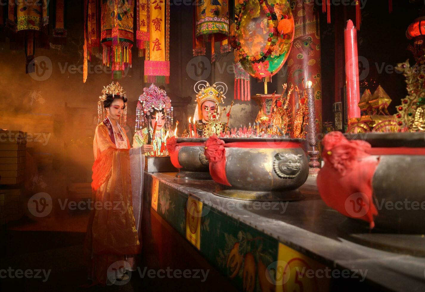 masculino e fêmea chinês ópera atores luz uma vela para orar homenagem para a Deuses para realçar a prosperidade para você mesmo em a ocasião foto