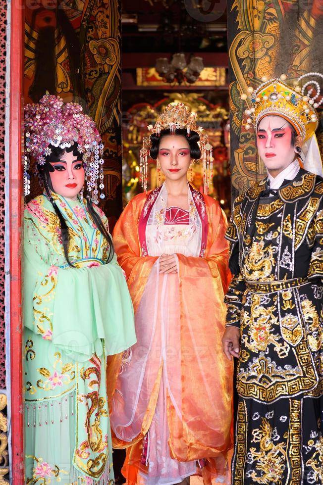 retrato do masculino e fêmea ópera artistas às a Entrada para uma sagrado santuário ou têmpora, Rezar para bênçãos em a ocasião do a anual chinês Novo ano. foto