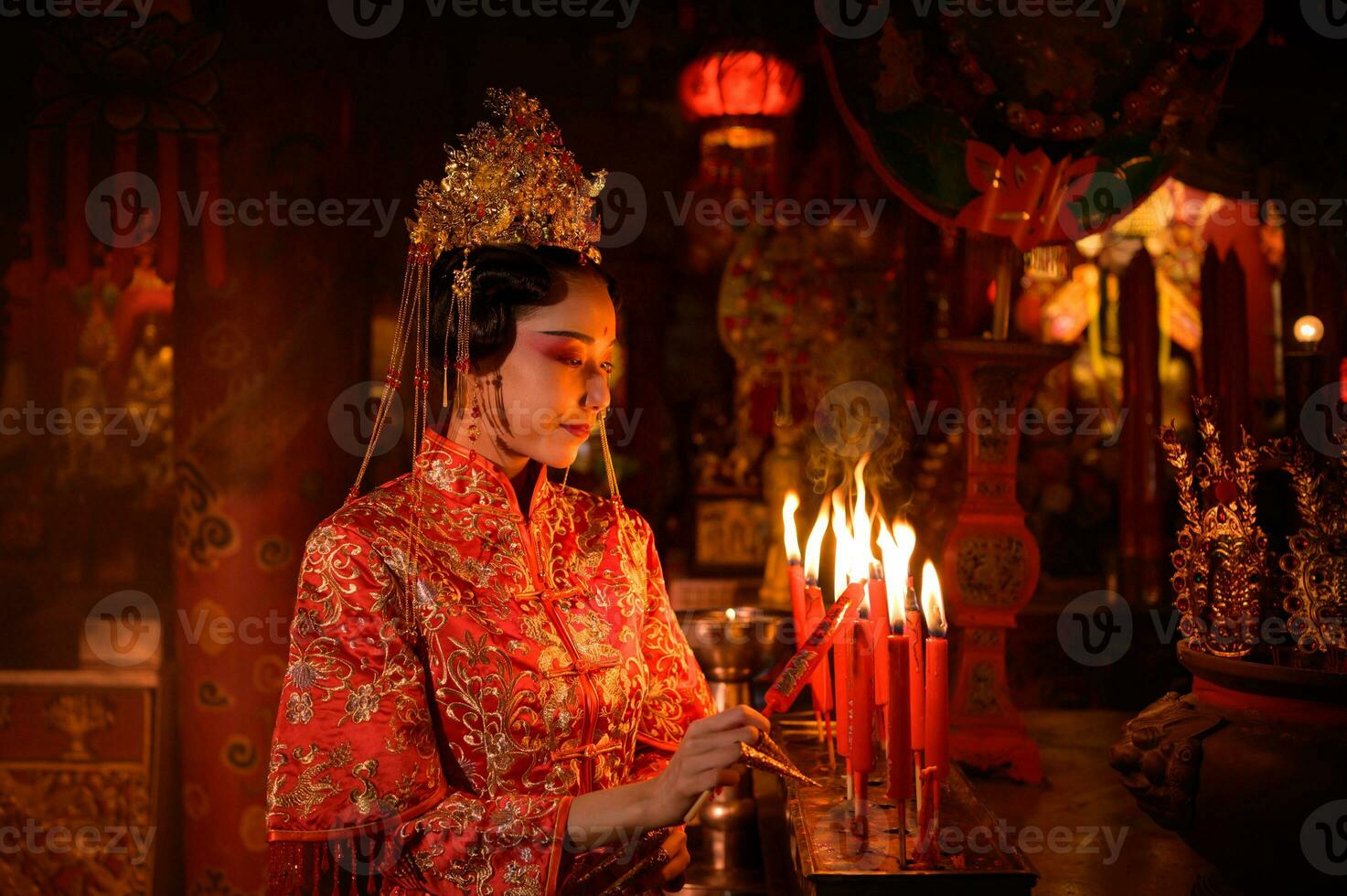 chinês mulher faço desejos, rezar, e luz velas. em a ocasião do a anual chinês Novo ano festival, dentro uma reverenciado santuário ou têmpora foto