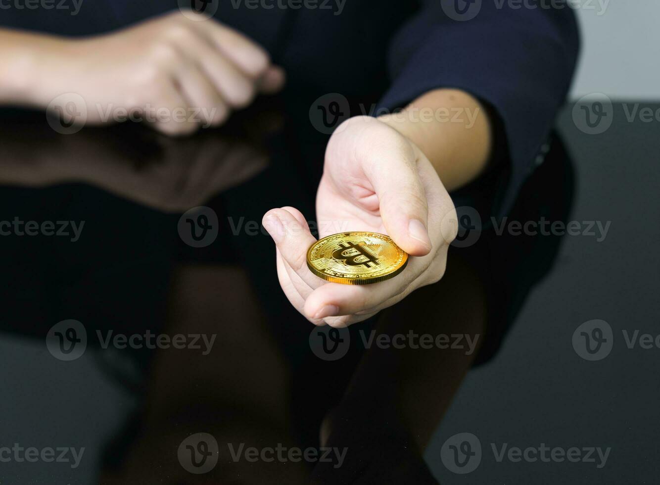 close-up de empresária segurando alguns pedaços de token bitcoin dourado foto