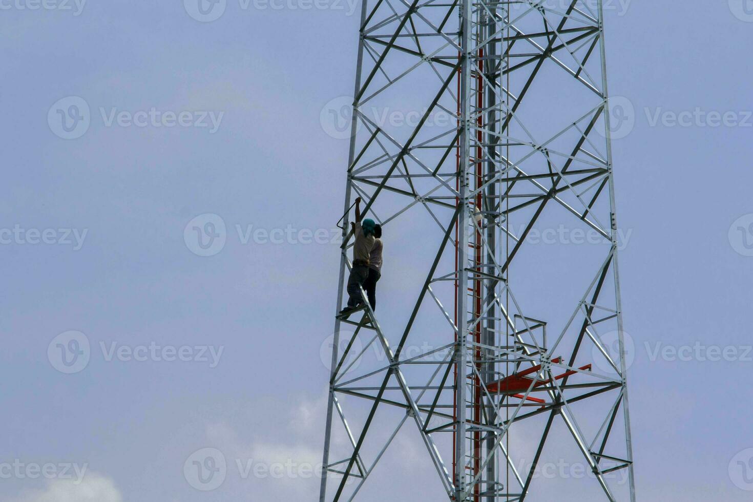 pintar antenas de celular e internet para realçar a beleza de jovens trabalhadores corpulentos com audácia de alcançar alturas é um trabalho perigoso. foto