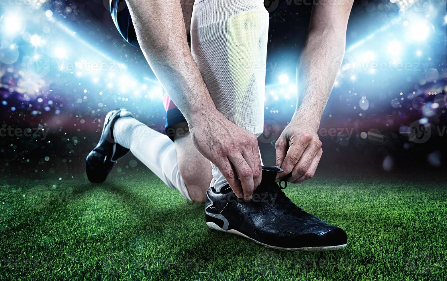 futebol jogador ajustar dele sapatos antes a Combine foto