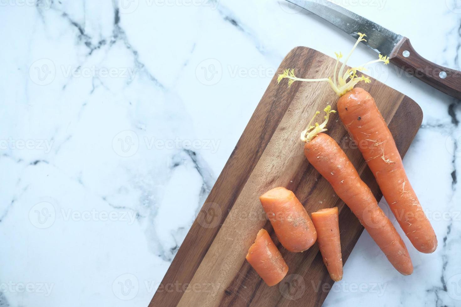 cenouras frescas na tábua de cortar foto