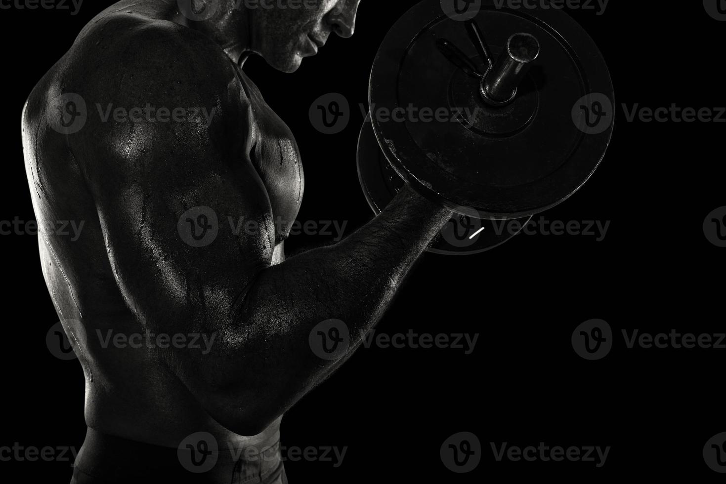 Atlético homem Treinamento bíceps às a academia. Preto e branco efeito foto