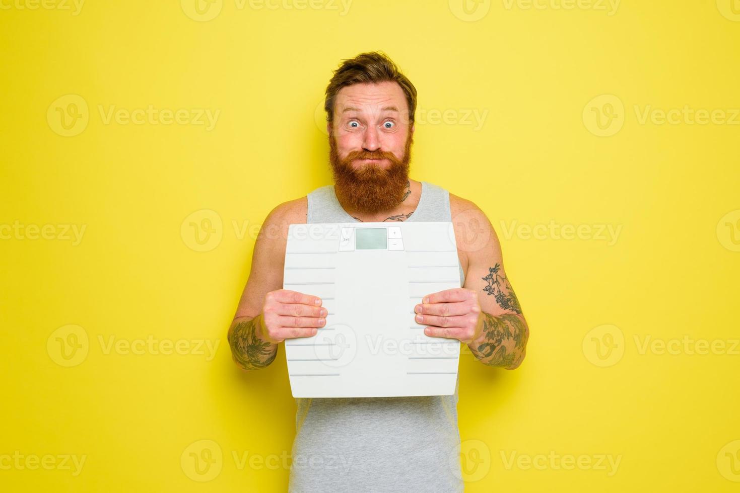 homem com barba e tatuagens detém a eletrônico Saldo foto