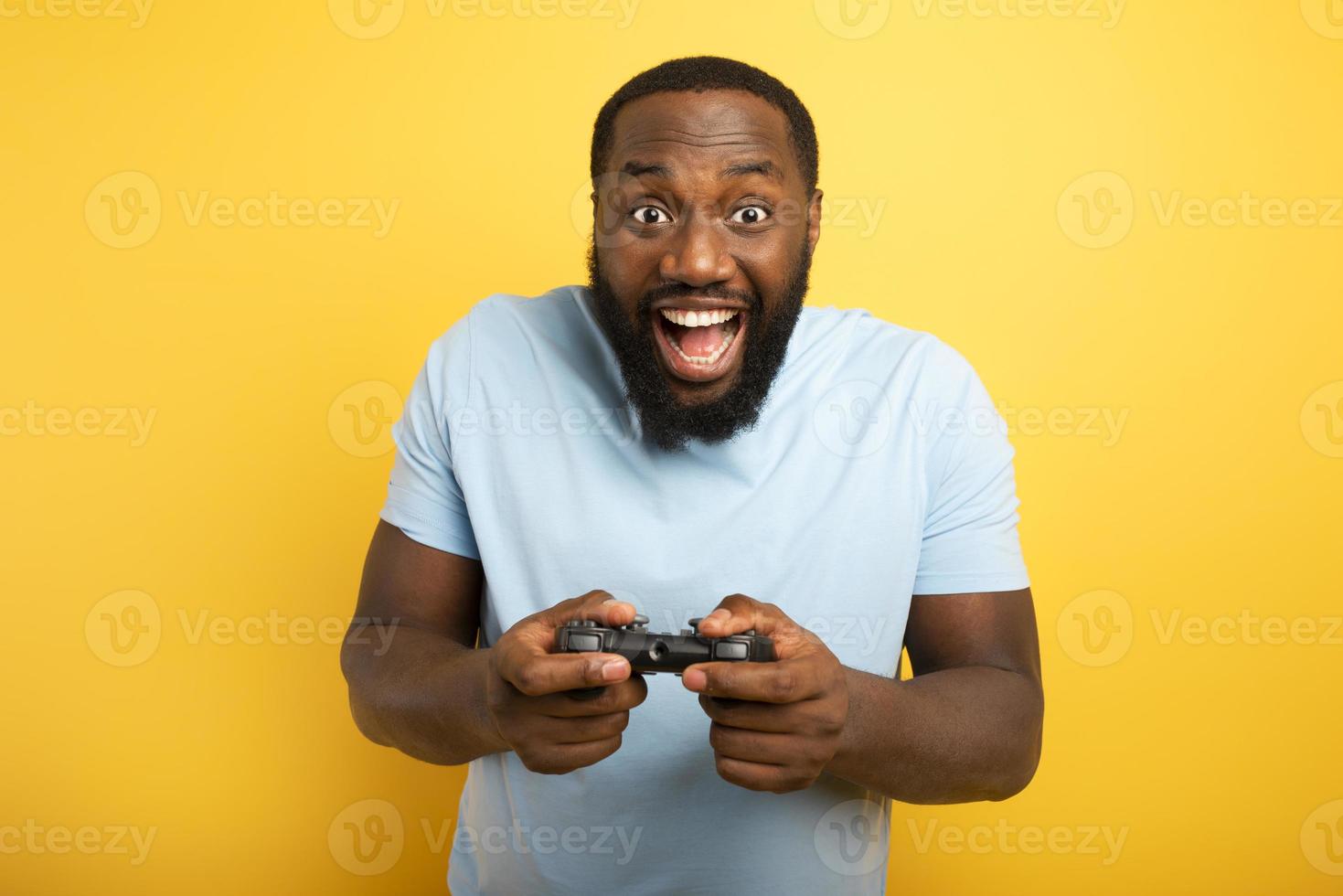 feliz homem tocam com uma videogame em amarelo fundo foto