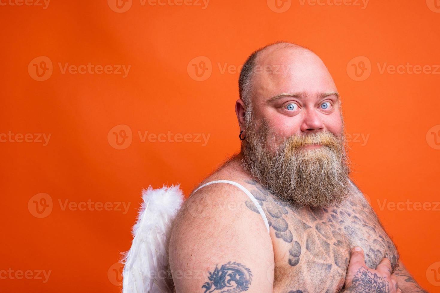 gordo feliz homem com barba , tatuagens e asas atos gostar a anjo foto