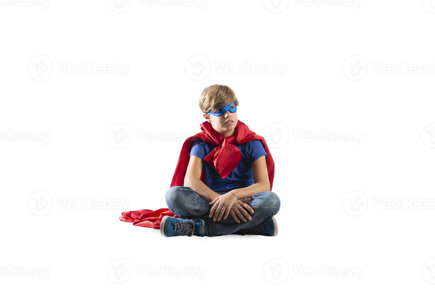 Super heroi criança sentado em uma parede este sonhos. isolado em branco fundo foto