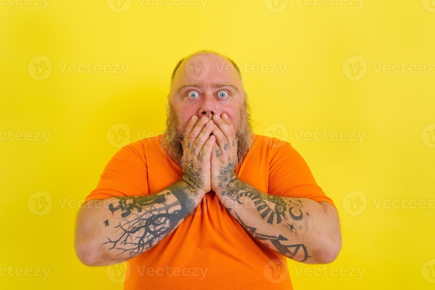 receoso homem com barba e tatuagens é preocupado sobre alguma coisa foto