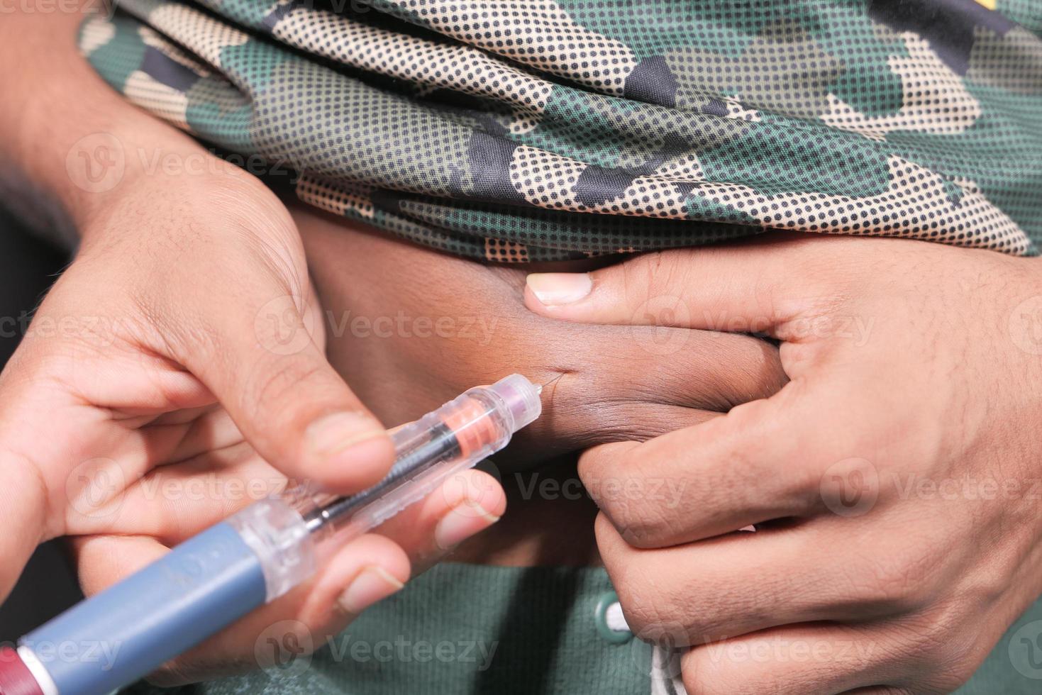 pessoa furando o estômago com caneta de insulina foto