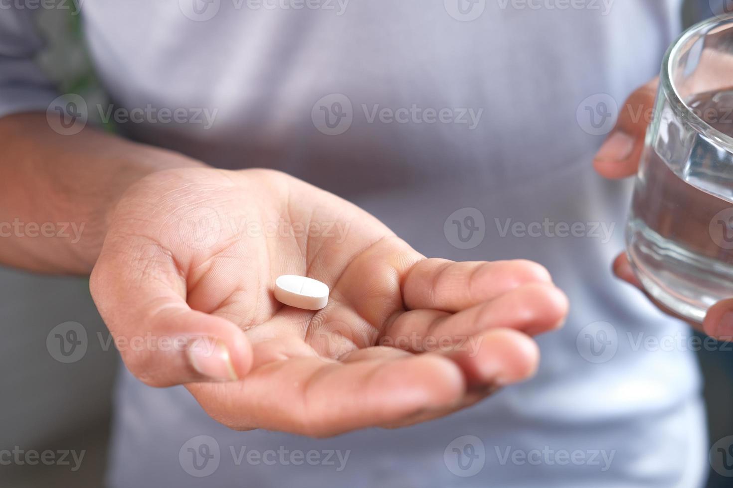 homem segurando uma pílula branca foto