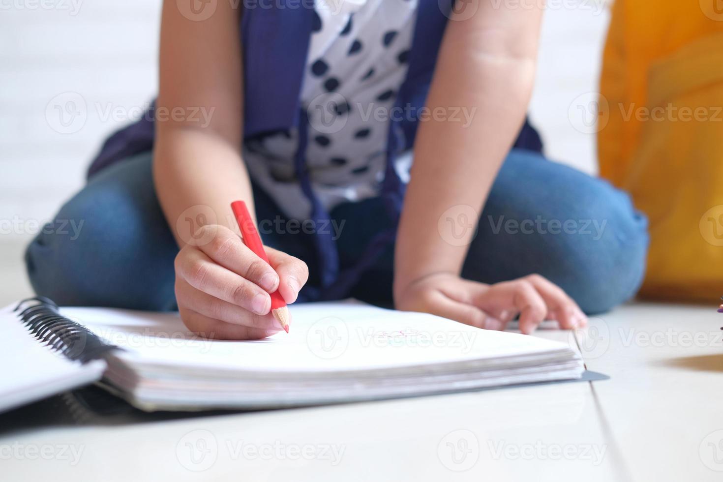criança desenhando em um caderno foto