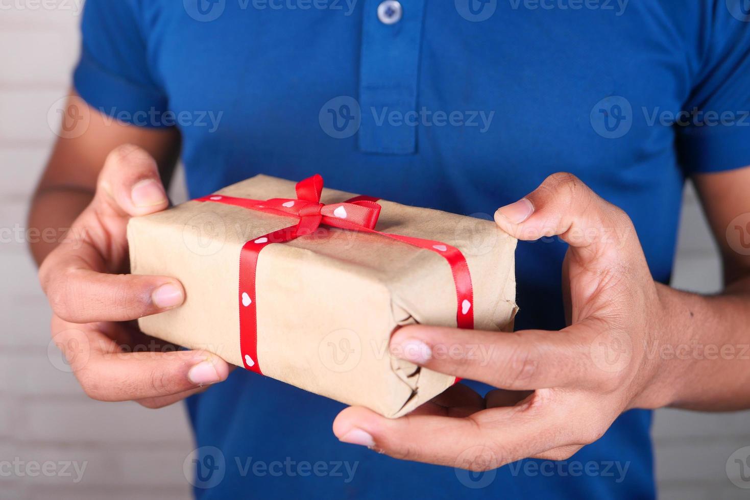 homem segurando um presente de dia dos namorados foto