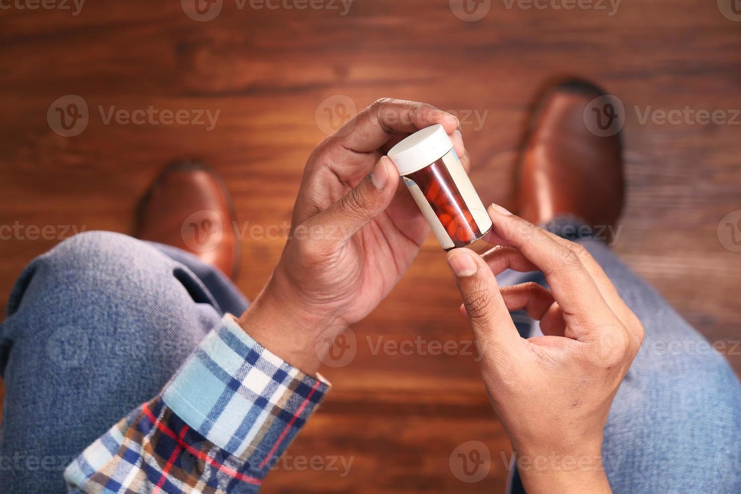 pessoa segurando um frasco de comprimidos foto