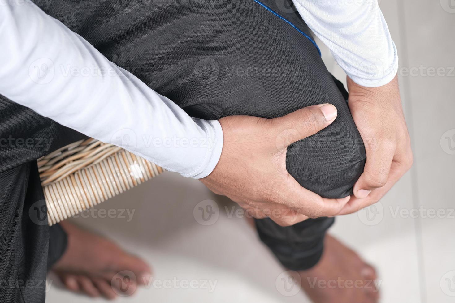 homem segurando o joelho com dor foto