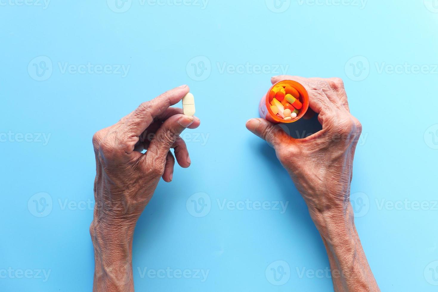 mulher tomando comprimidos em fundo azul foto