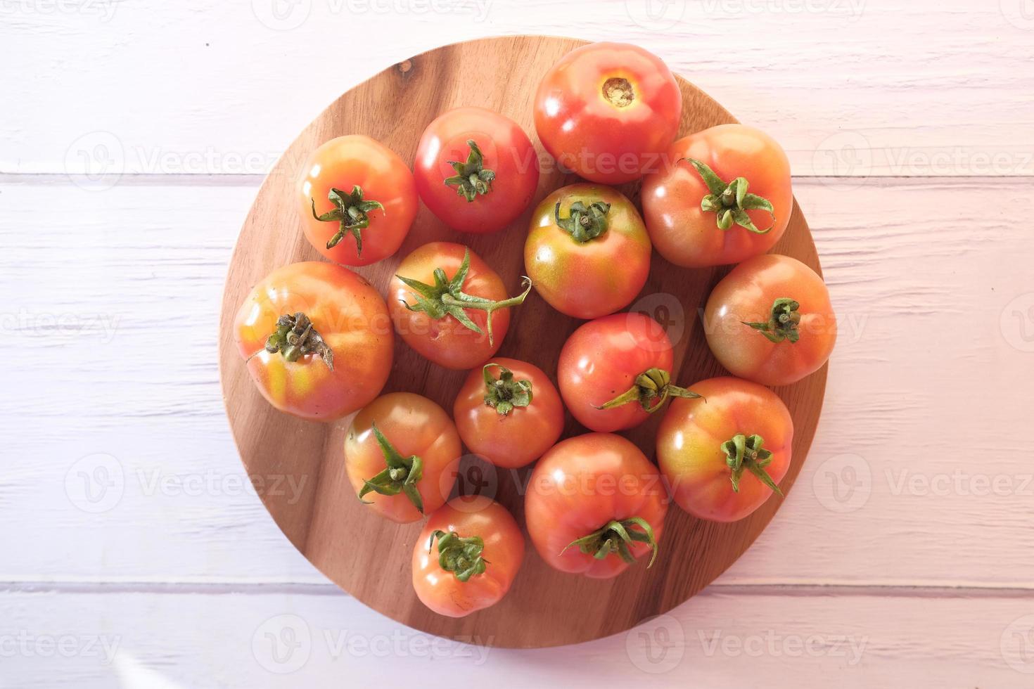 tomates frescos em uma tábua de cortar foto
